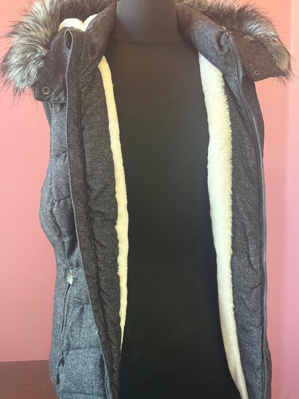 Black outer vest with detachable hood and synthetic furry white lining